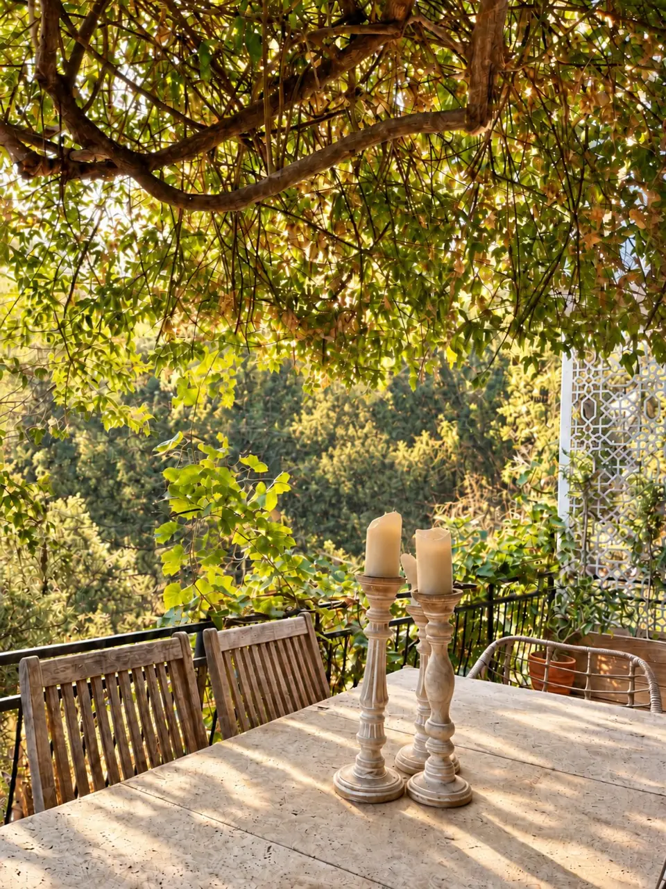 Terrasse sous une pergola, bougies sur une table en pierre